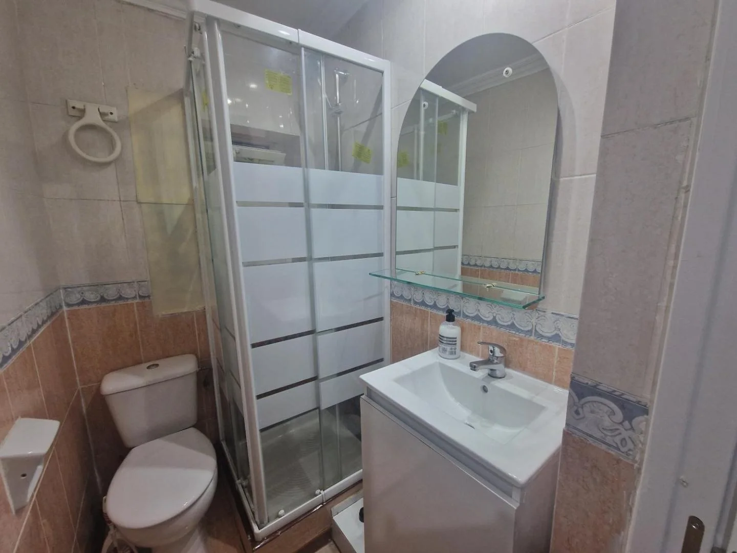 Baño con ducha de mampara y lavabo