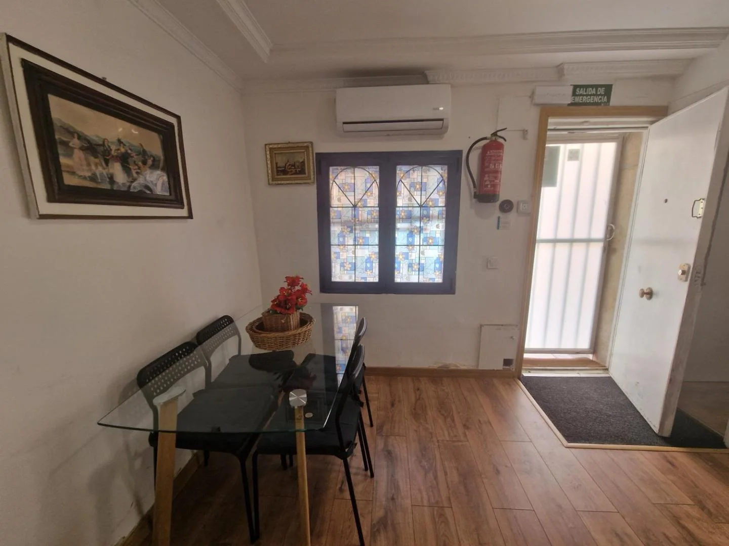 El comedor, con mesa de cristal y aire acondicionado
