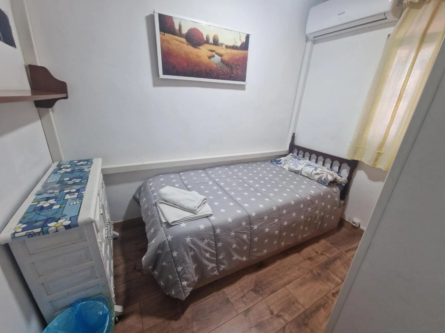 Dormitorio con cama doble y cuadro de campos