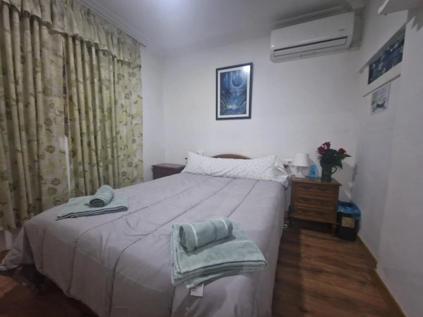 Dormitorio con cama doble, toallas y aire acondicionado