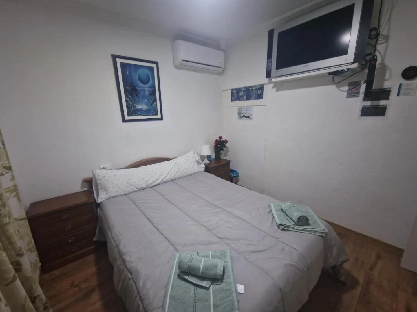 Dormitorio con cama doble y televisión