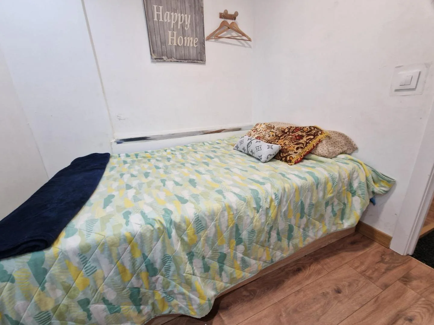 Dormitorio individual con colcha de colores